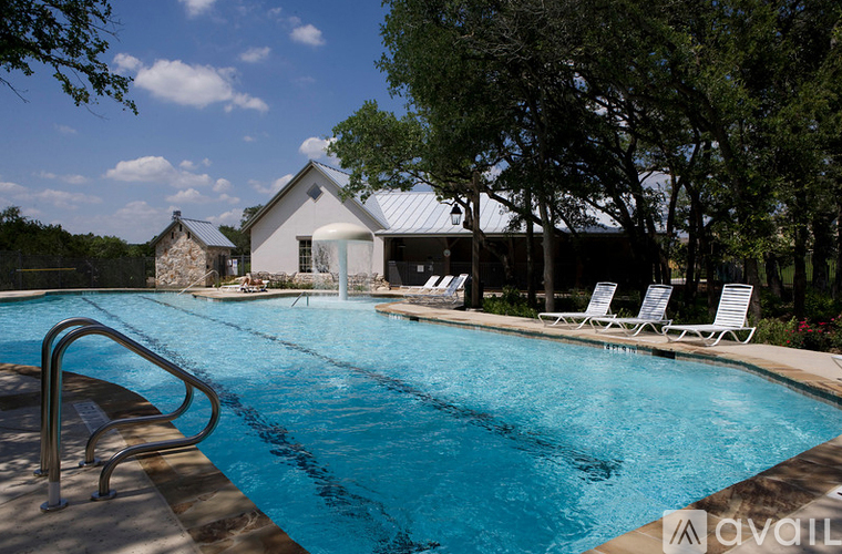 A pool with a metal ladder and a house in the background.