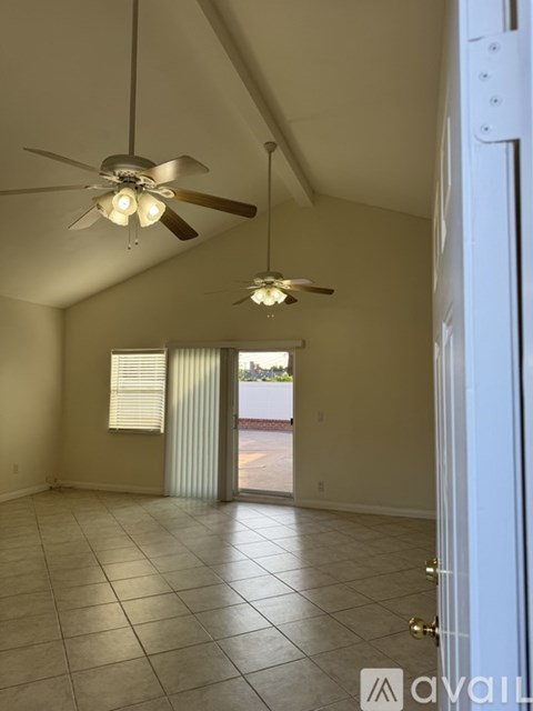 A room with a ceiling fan and a door.