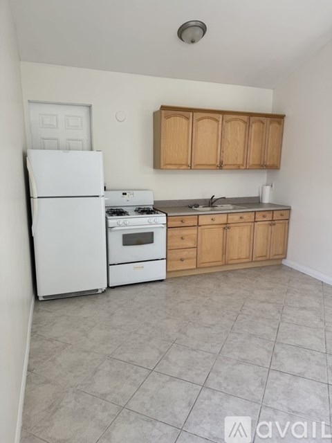 A kitchen with white appliances and wooden cabinets.