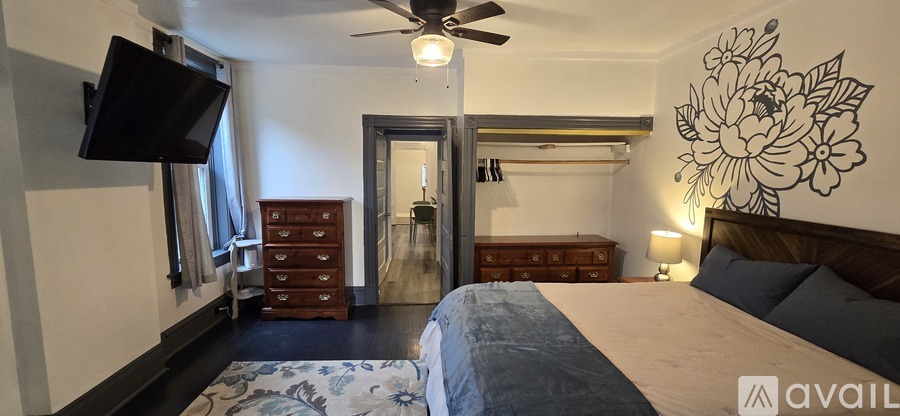 A bedroom with a large bed and a ceiling fan.