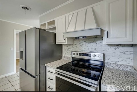 A modern kitchen with a stainless steel refrigerator and oven.