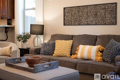 A living room with a grey couch and a wooden coffee table.