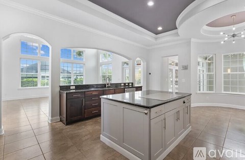 A spacious kitchen with a large island and arched windows.