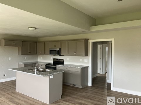 A kitchen with a sink, stove, and cabinets.