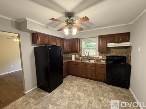 A kitchen with black appliances and wooden cabinets.