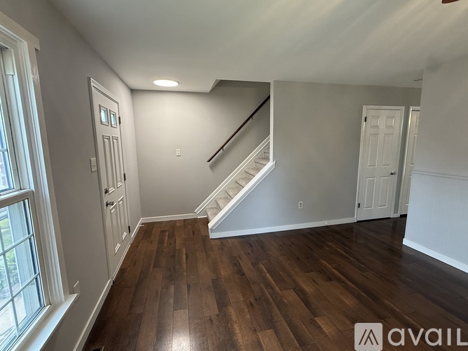 A room with wooden floors and a staircase.