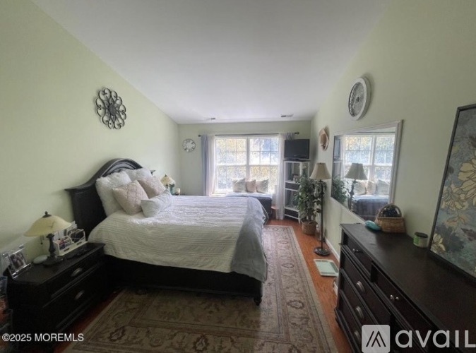 A bedroom with a large bed and a window with a view.