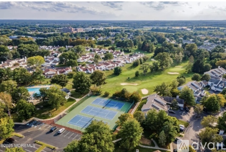 A bird's eye view of a residential area with a tennis court and a swimming pool.