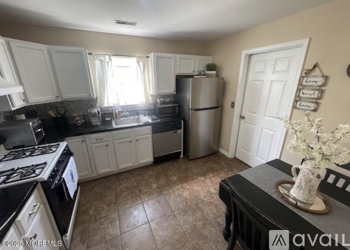 A kitchen with white cabinets and a black stove top.