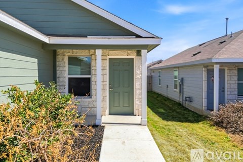 A house with a green door and a small front yard.