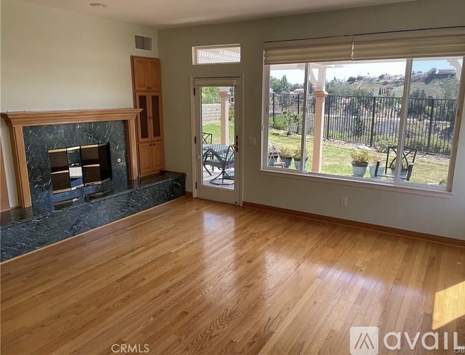 A living room with a fireplace and wooden floors.