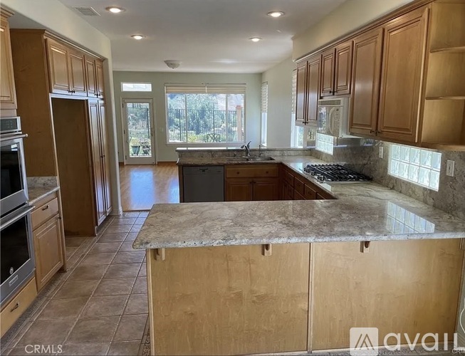 A kitchen with wooden cabinets and a marble countertop.