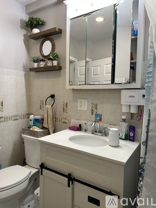 A bathroom with a toilet, sink, and mirror.