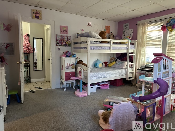 A child's bedroom with bunk beds and a play area.