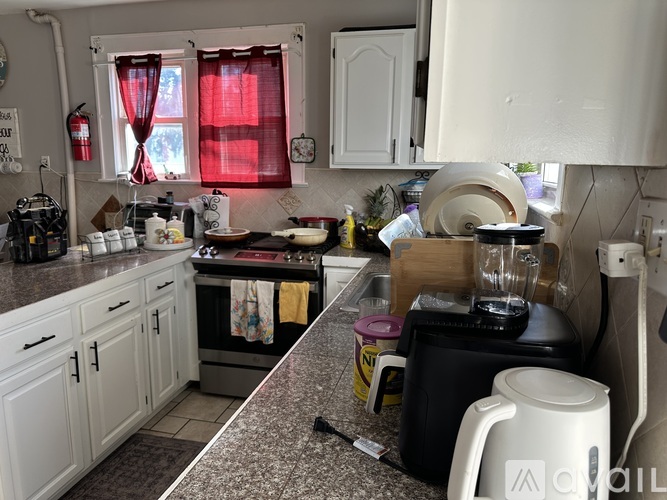 A kitchen with a white counter and a black toaster.