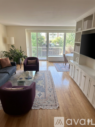 A living room with a purple chair and a glass table.
