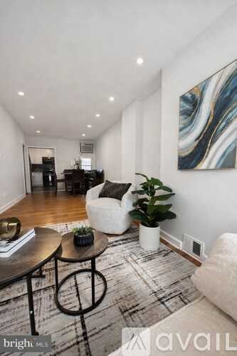 A living room with a couch, coffee table, and a painting on the wall.