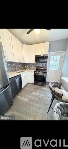 A kitchen with a black stove top oven and a black counter top.