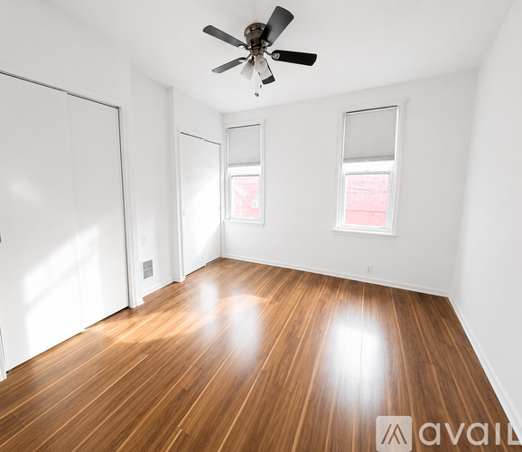 A room with wooden flooring and a ceiling fan.