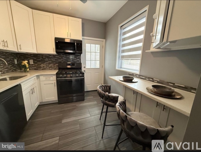 A kitchen with a black stove top oven and white cabinets.