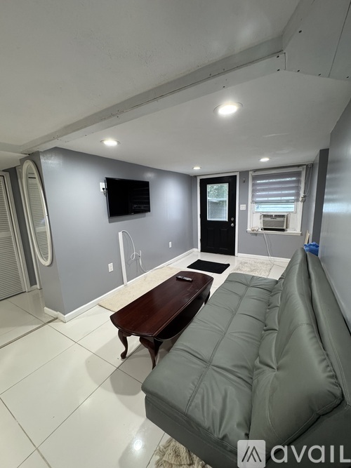 A living room with a grey couch and a wooden table.