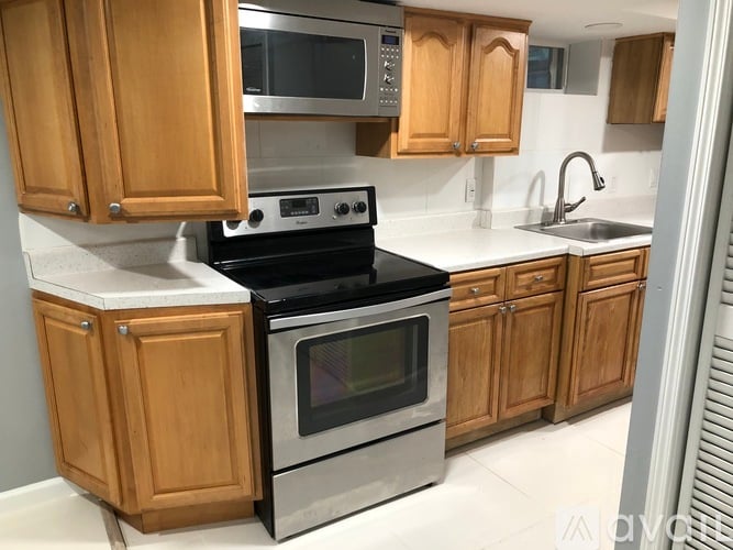 A kitchen with wooden cabinets and a stainless steel oven.