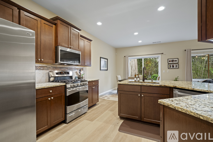 A kitchen with wooden cabinets and granite countertops is available for rent.