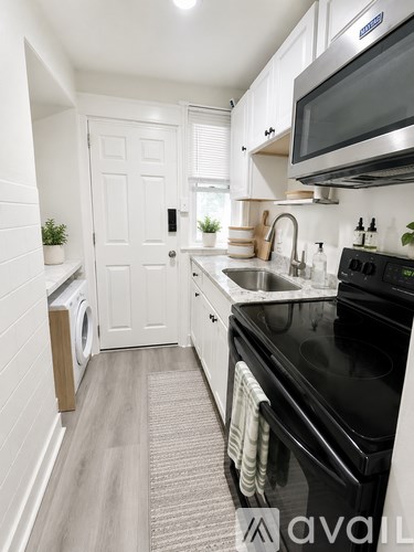A kitchen with a black oven and white cabinets.
