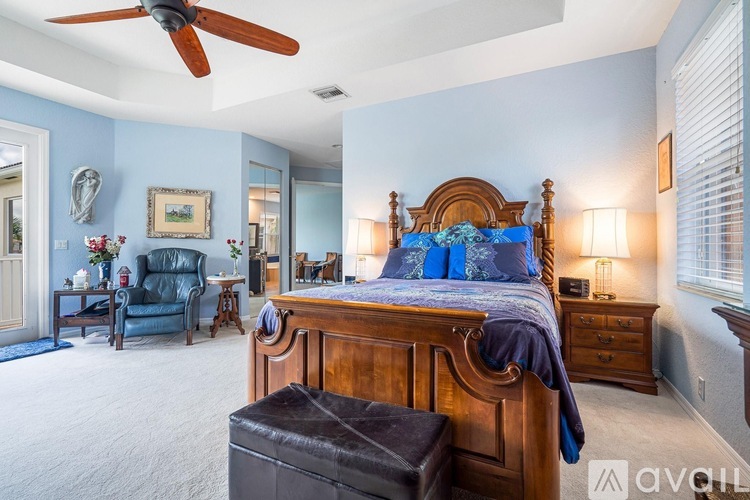 A bedroom with a large bed and a ceiling fan.