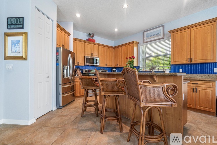 A kitchen with wooden chairs and cabinets.