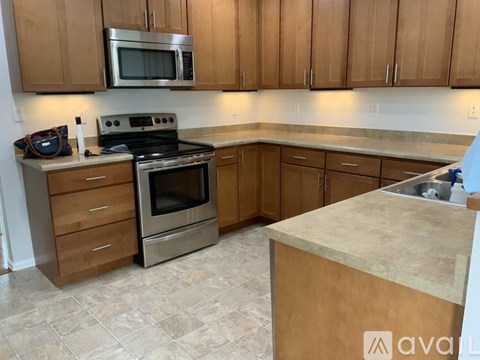 A kitchen with wooden cabinets and a stainless steel oven.