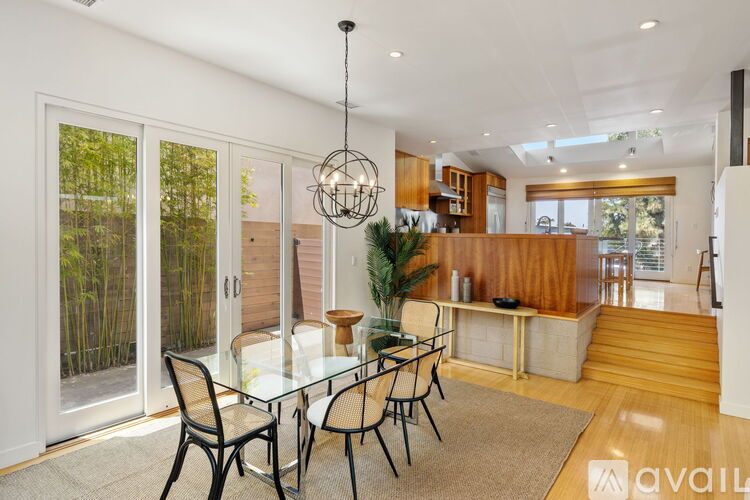 A modern dining room with a glass table and chairs.