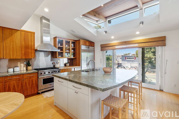 A kitchen with wooden cabinets and a marble countertop.