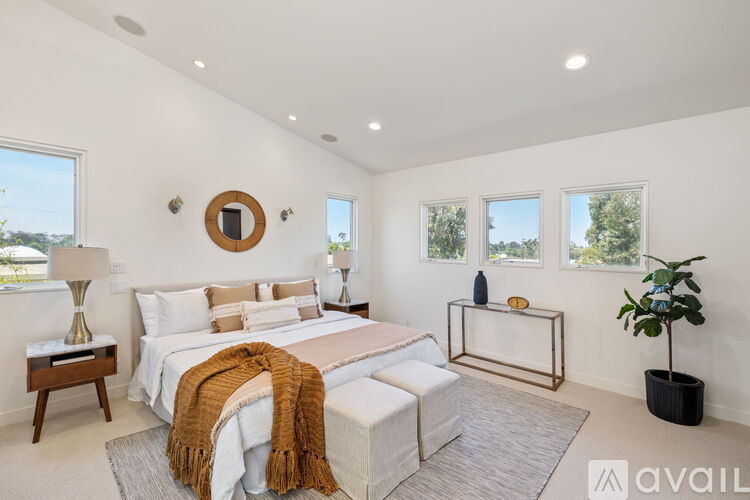A bedroom with a large bed and a mirror on the wall.