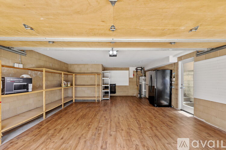 A spacious room with wooden floors and a high ceiling.
