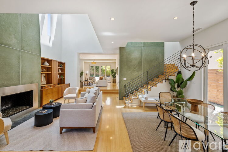 A living room with a fireplace and a dining table with chairs.