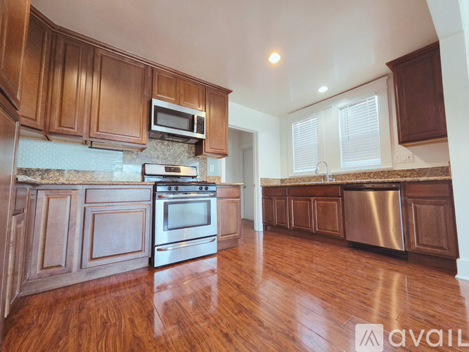 A kitchen with wooden cabinets and a stone backsplash.