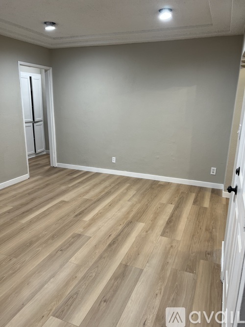 A room with wooden flooring and a white door.