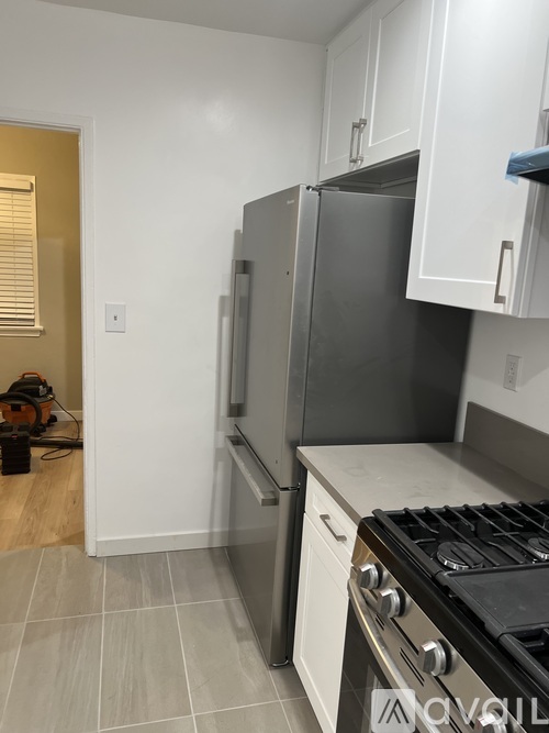 A kitchen with a stove, refrigerator, and cabinets.