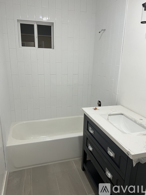 A white bathroom with a tub and sink.
