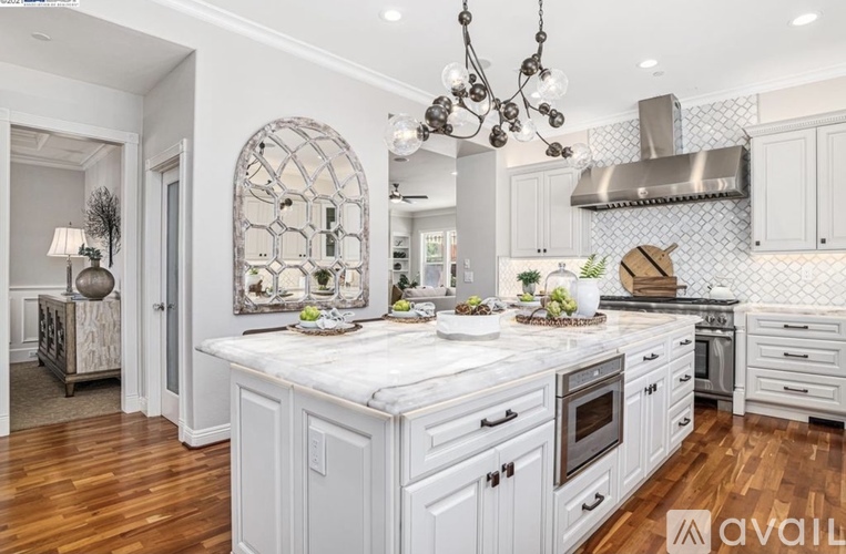A modern kitchen with a large island and wooden floors.