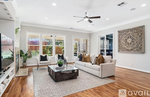 A living room with a white couch, a coffee table, and a large painting on the wall.