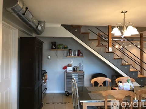 A kitchen with a stainless steel refrigerator and a dining table with chairs.