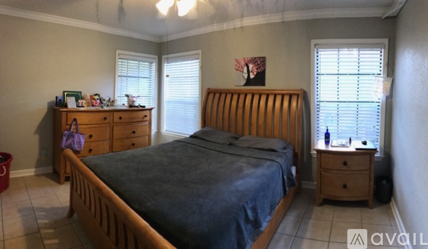 A bedroom with a bed, dresser, and window.