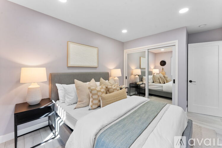 A bedroom with a large bed and a mirror on the wall.