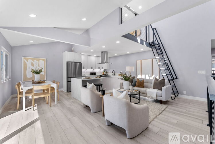 A modern living room with a dining table and a kitchen area in the background.