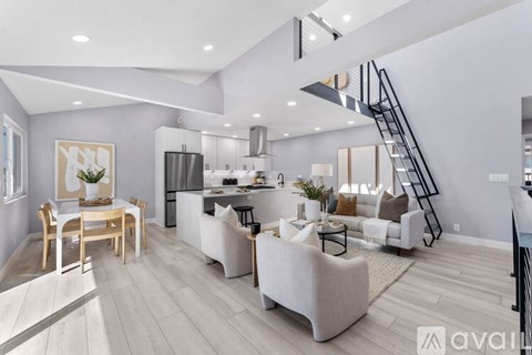 A modern living room with a dining table and a kitchen area in the background.