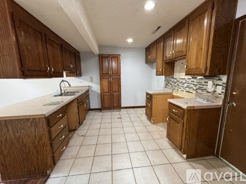 A kitchen with wooden cabinets and a white countertop.