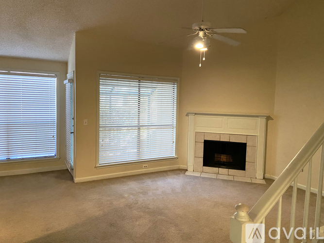 A living room with a fireplace and a ceiling fan.
