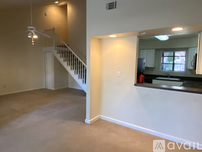 A spacious room with a staircase and a mirror on the wall.